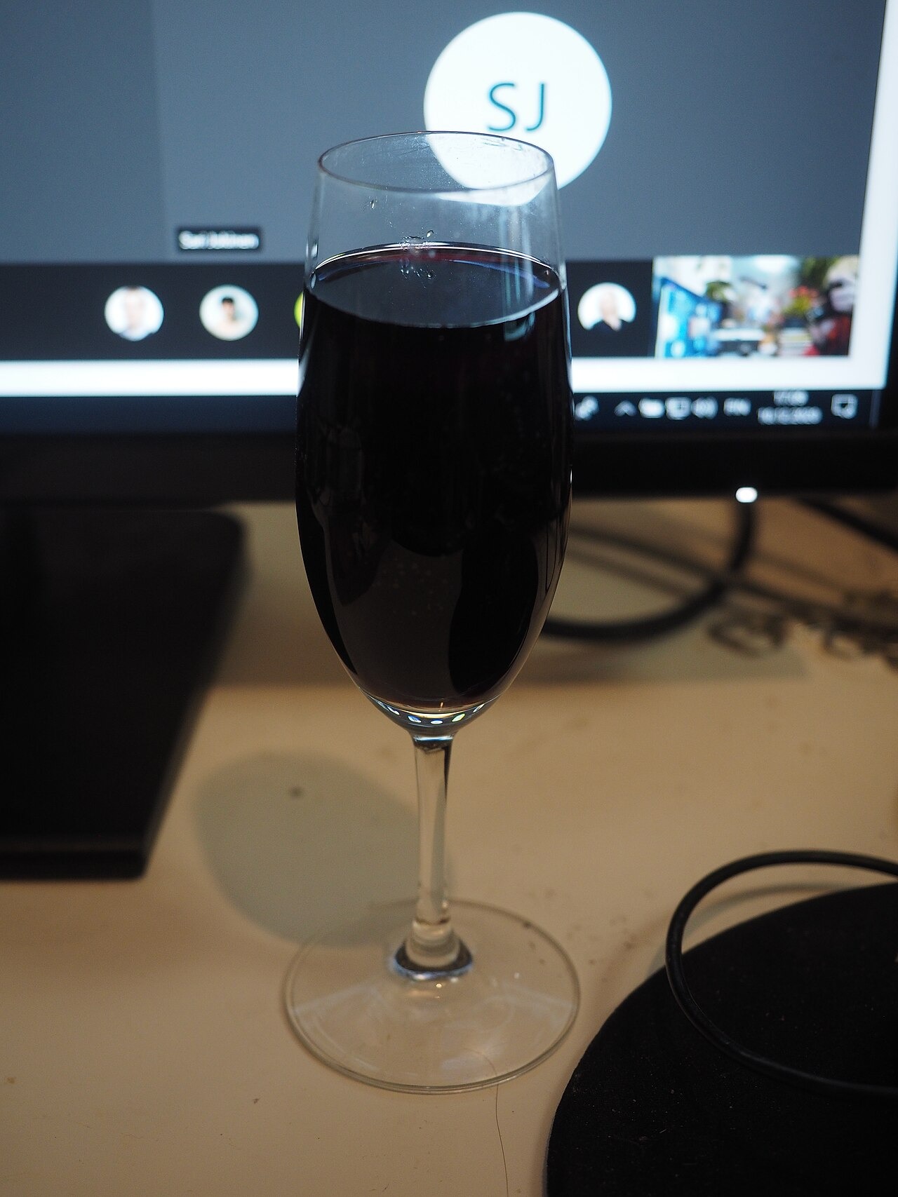 File photo: A Microsoft Teams meeting displayed on a computer during an online company party, photographed behind a glass of wine. Illustrative context; not a photograph of the reported event.